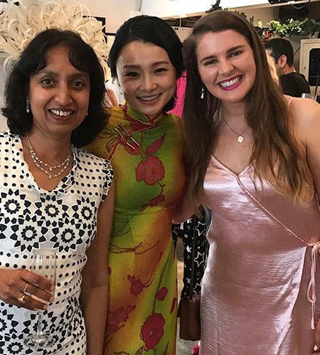 Three female team members dressed formally, smiling