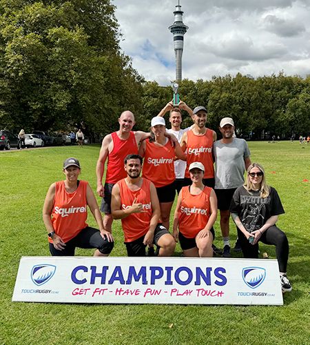 Group of touch rugby players in with Champions sign in front