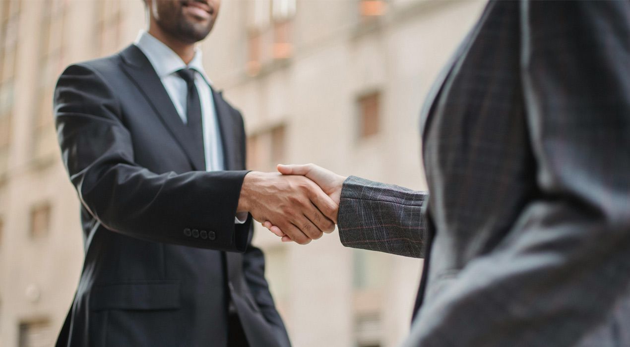 Two men in business suits shaking hands