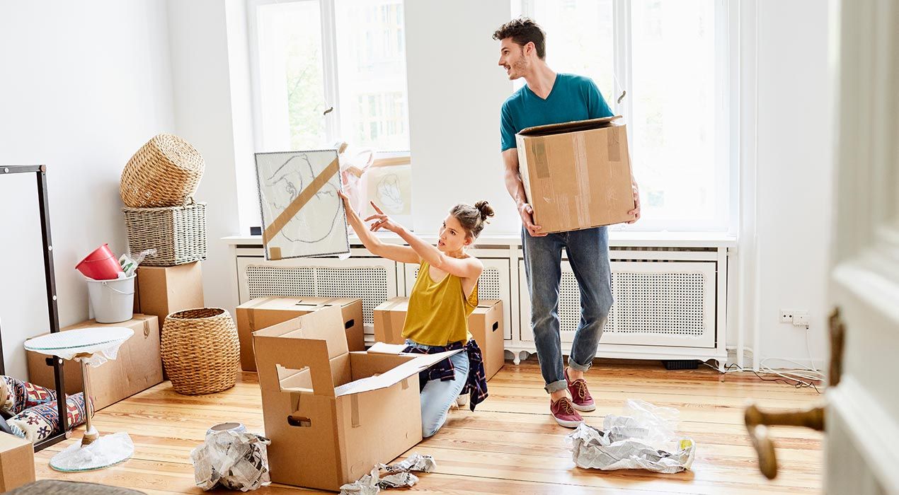 Young couple unpacking boxes, moving into their new home