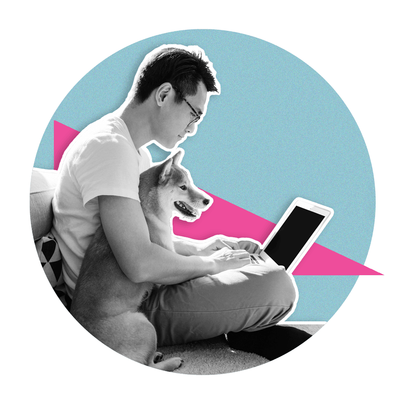 Man sitting on floor with dog, looking at laptop