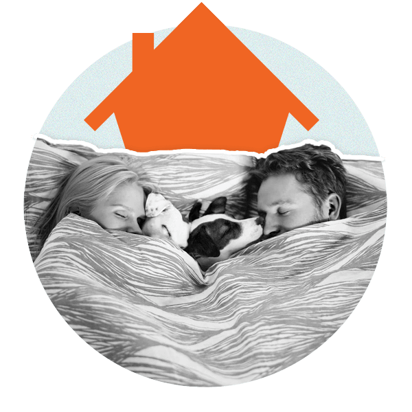 Couple in bed with dog. Orange house behind them.