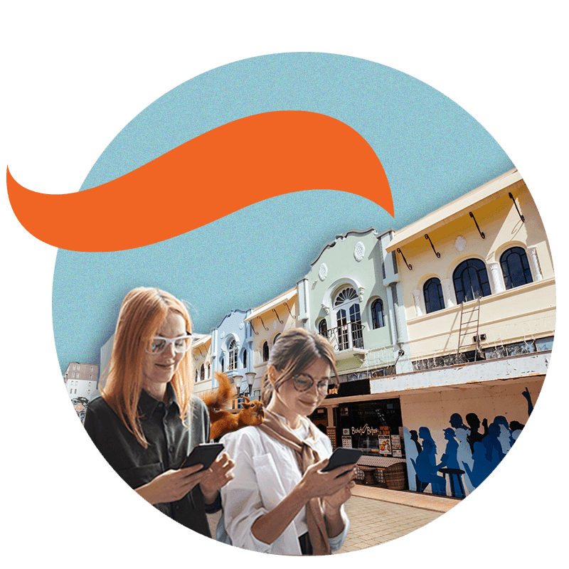 Two ladies walking looking at phones. Squirrel sitting on shoulder of one lady. Christchurch heritage buildings in background.