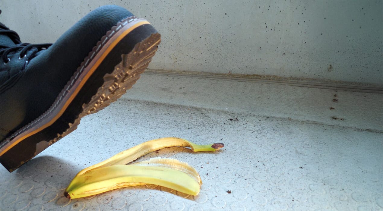 Close up of someone wearing a boot about to step on a banana peel